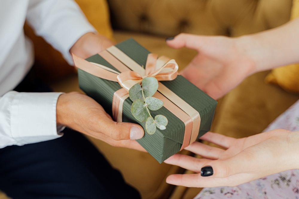 A gift being presented from one pair of hands to another